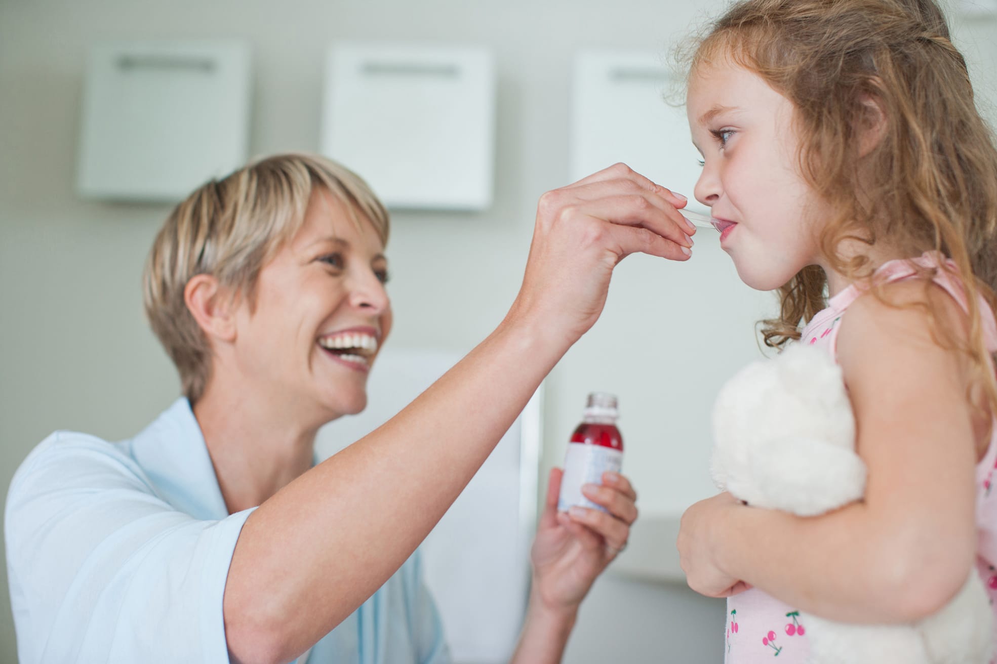Mother giving daughter medicine