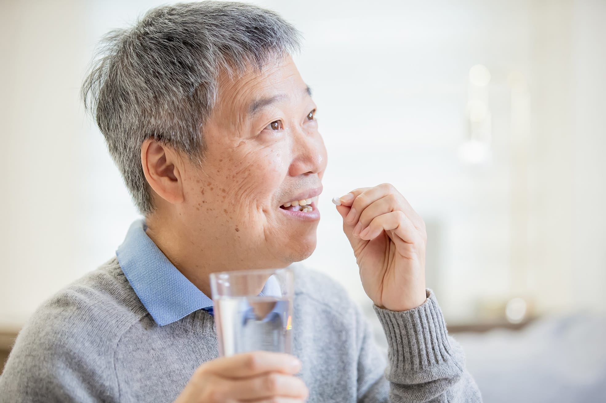 old asian man take medicine